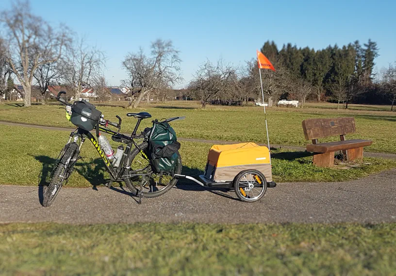 Fahrradanhänger mit Fahrrad auf einem Feldweg