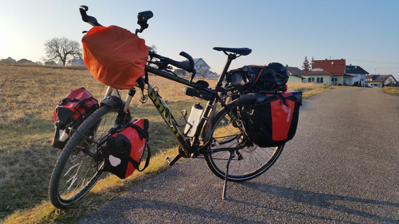 Fahrrad mit Taschen an der Gabel vorne, Gepäckträgertaschen hinten und Lenkertasche.